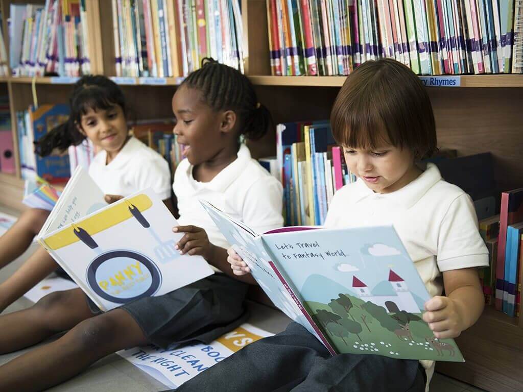 Young students reading books in a library corner