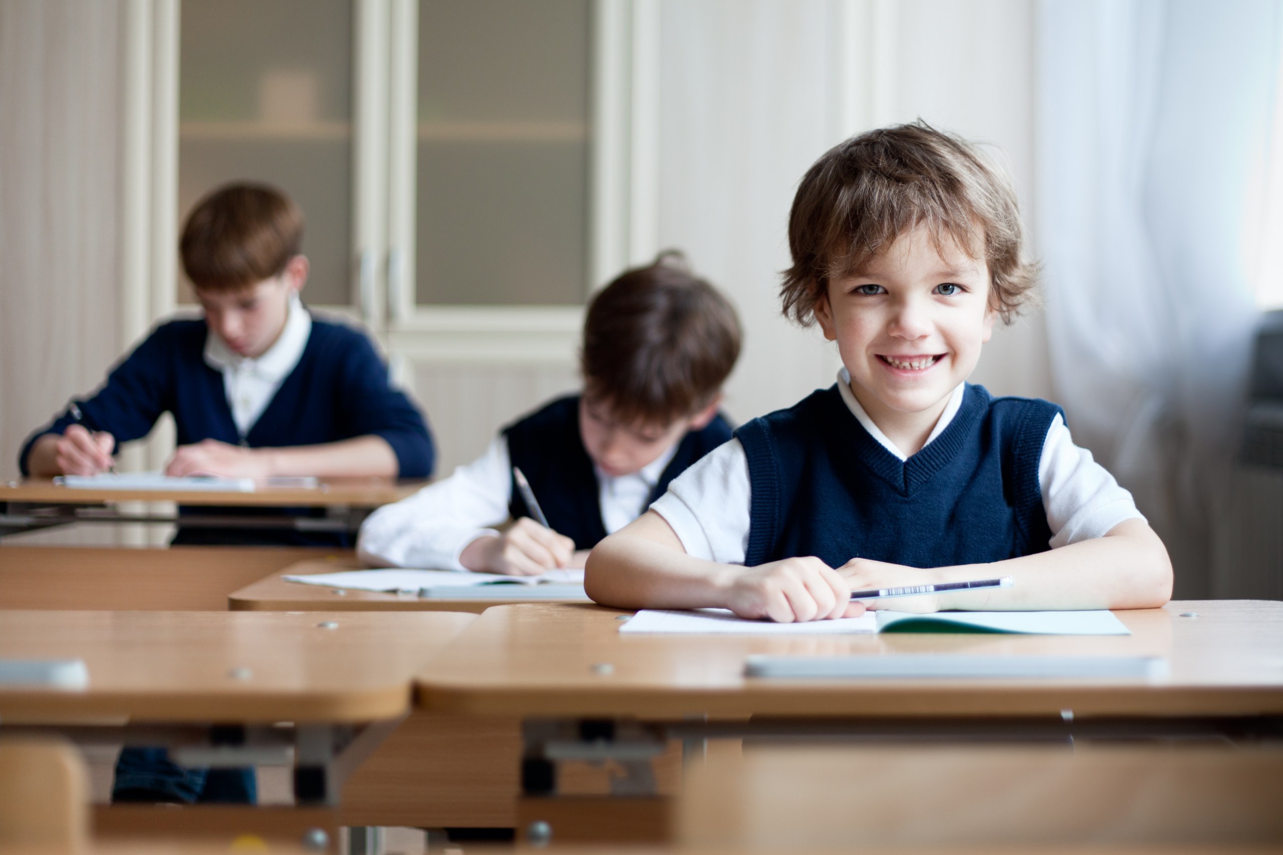 Happy,Schoolboys,Sitting,At,Desk,,Classroom